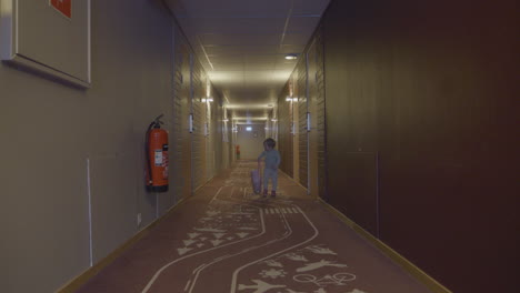 young traveling toddler walking down hotel hallway alone