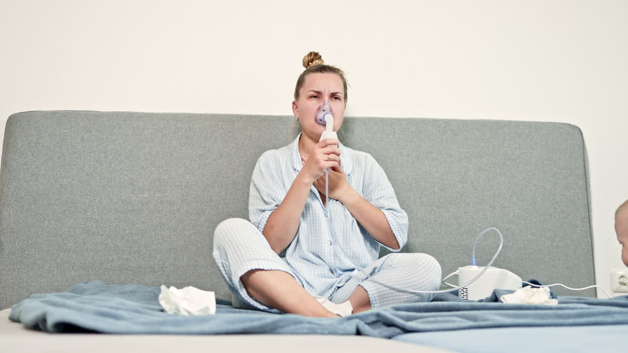 Una giovane donna utilizza un nebulizzatore a casa per alleviare le difficoltà respiratorie, sottolineando il ruolo essenziale dell'assistenza respiratoria nel migliorare il suo benessere durante le condizioni di salute.