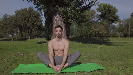 Langsame-Filmische-Aufnahme-Eines-Hübschen-Jungen-Kaukasischen-Mannes,-Der-Im-Park-Eine-Youga-Stretch-Pose-Macht