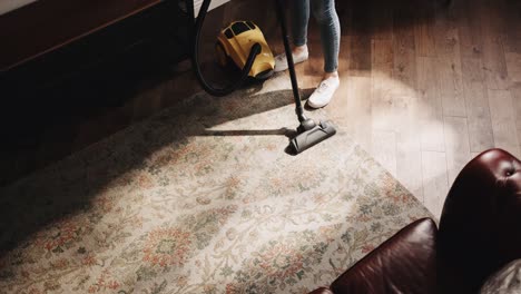 woman is vacuum cleaning at home, domestic household maintenance concept