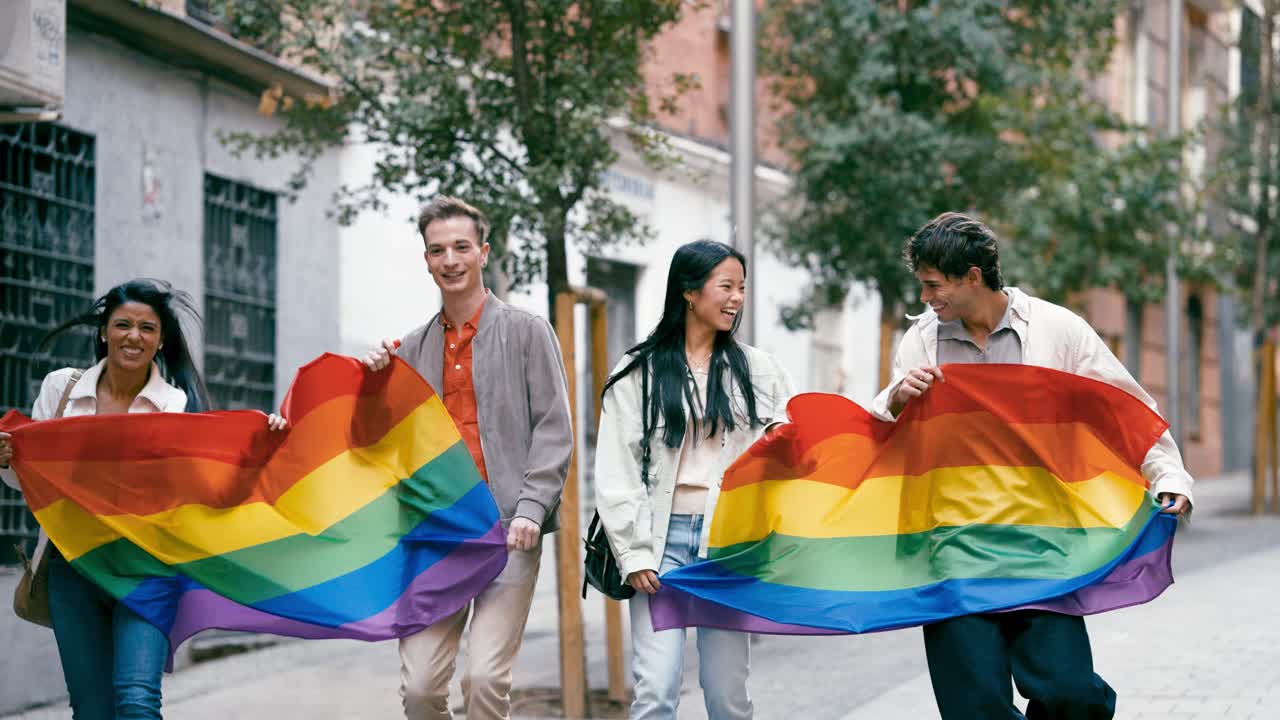 Group of people celebrating LGBTQ pride with a rainbow flag