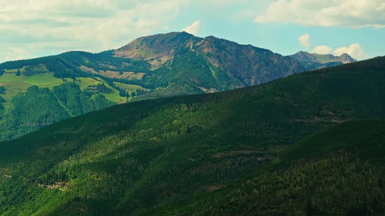 Aerial view of layered alpine terrain and forest textures near Vail with tree-lined slopes