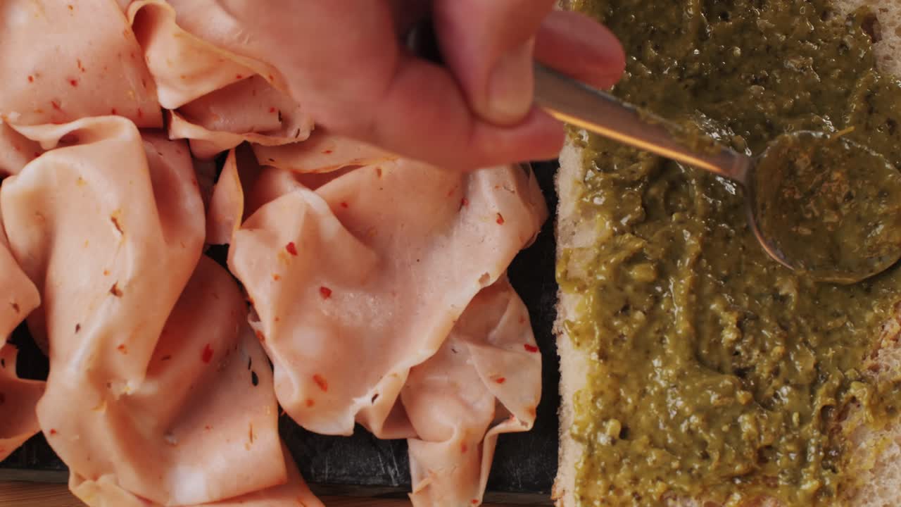 Ham italian mordatella, man Slices Of Traditional Italian antipasti mortadella sausage on a wooden cutting board, close up macro of chicken or turkey jamon, fat breakfast dish.