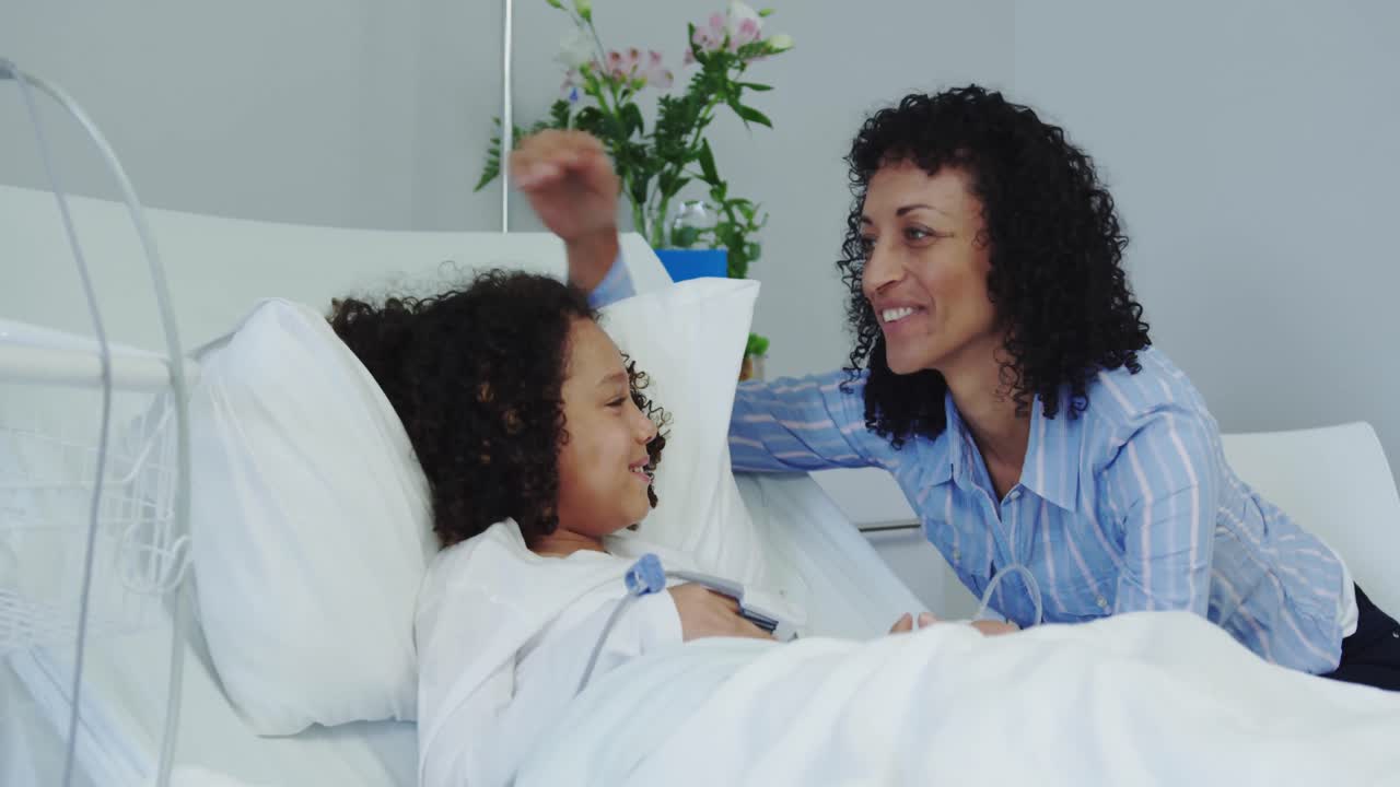 Front view of African american mother talking with her son in ward at hospital 4k
