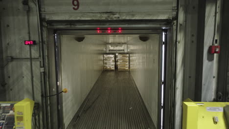 aerial drone flying inside semi-truck trailer parked at warehouse loading dock