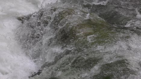 agua que fluye sobre la roca ubicada debajo de la corriente