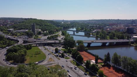 aerial drone view of traffic on road junction or crossroad, prague, czech republic, vltava river and city in background