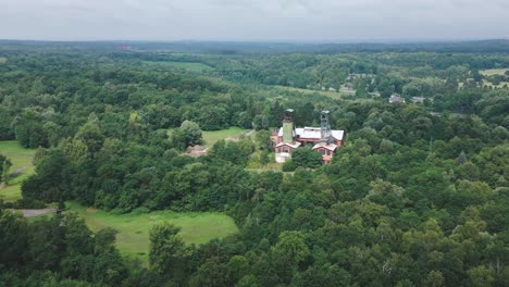 aerial shot reveals disused coal mine towers amid lush green landscape
