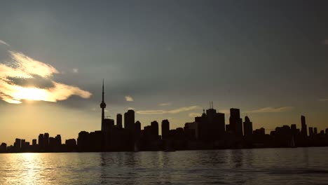 silhouetted toronto skyline in late afternoon sunset taken from a boat on the lake