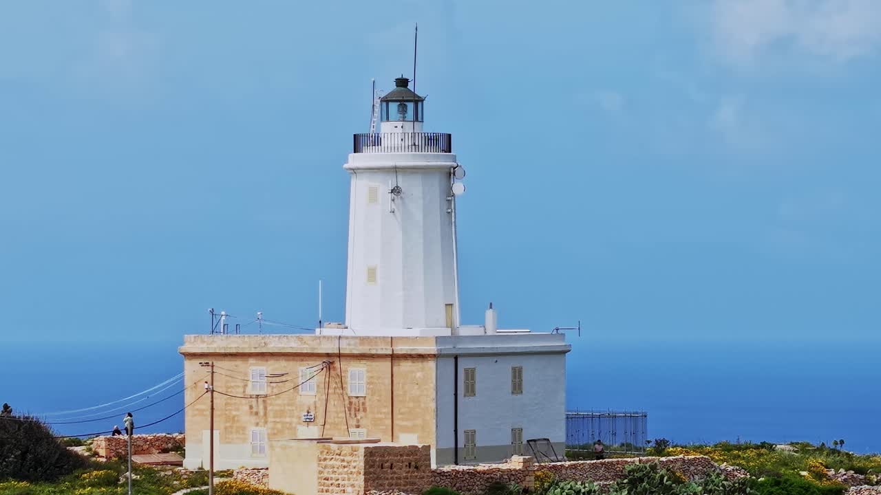 Il faro di Malta si erge imponente su un cielo blu vicino alla costa