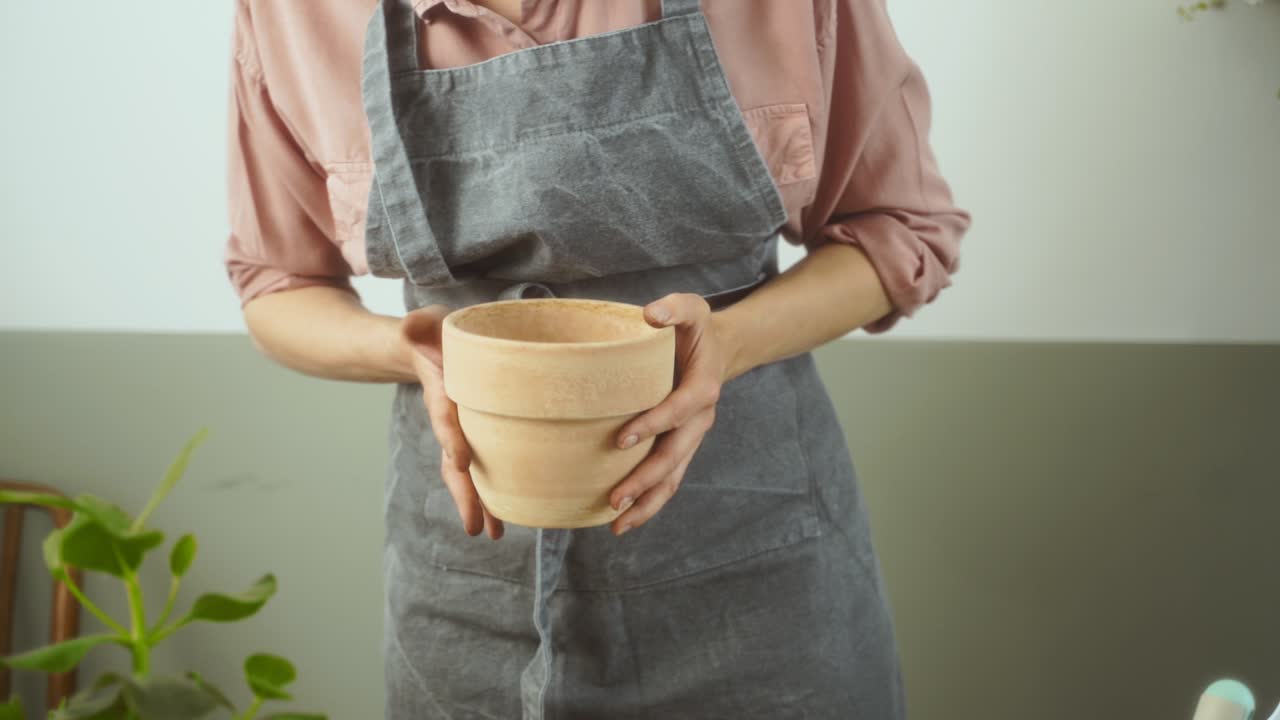 mujer de la cosecha preparando la olla para las plantas