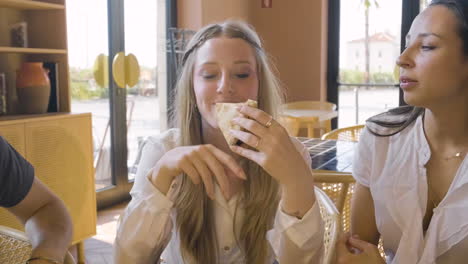 schönes blondes mädchen, das pizza mit freunden im restaurant isst