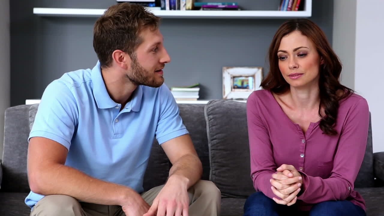 una pareja peleando en el sofá.