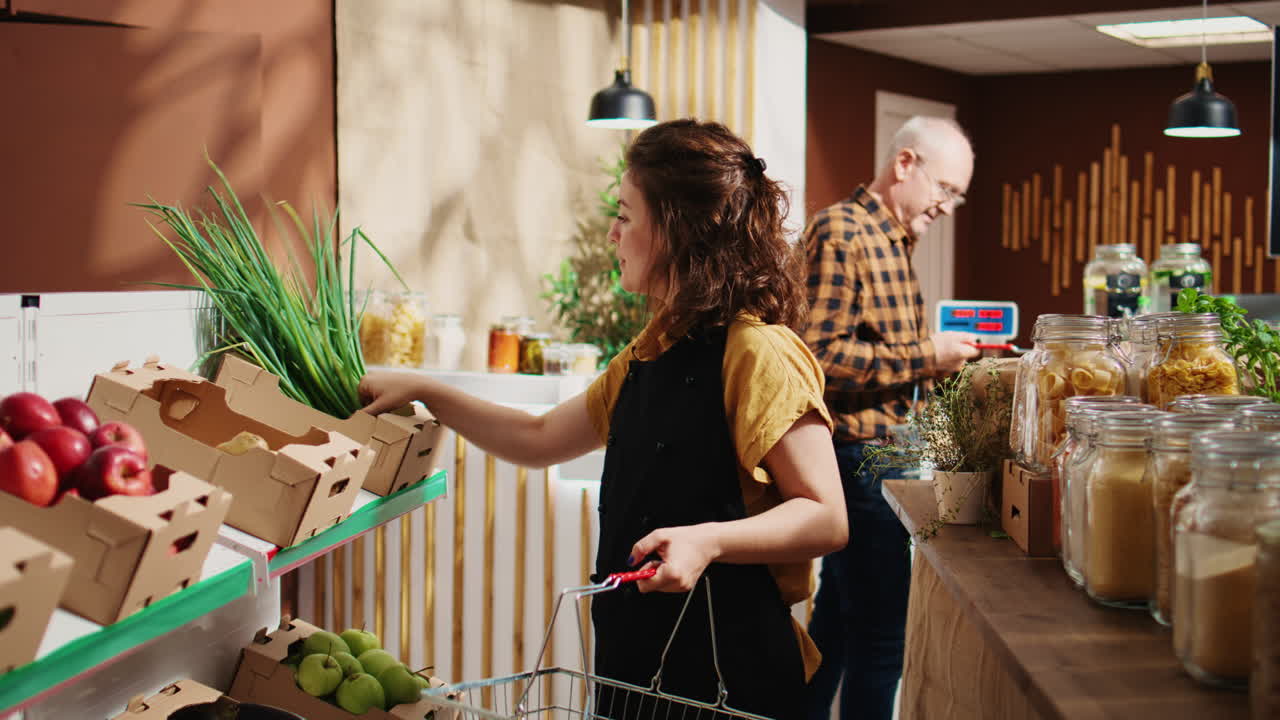 식료품 가게 직원이 선반을 재충전합니다.