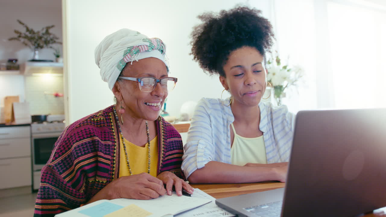 Black Woman and Senior Mother Video Calling on Laptop at Home