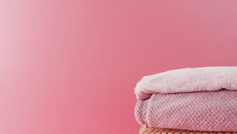 video of folded blankets lying on pink background