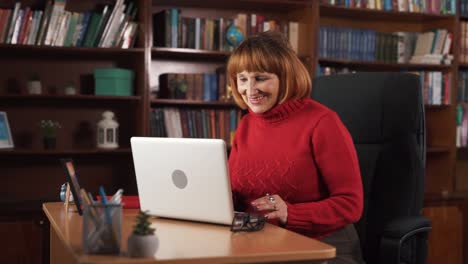 Eine-ältere-Frau-Sitzt-An-Einem-Tisch-Und-Arbeitet-An-Ihrem-Laptop