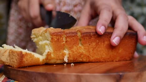 Slice-of-bakery-cake-on-chopping-board-on-white