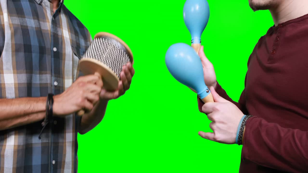 sección media de músicos masculinos tocando cabasa y maraca