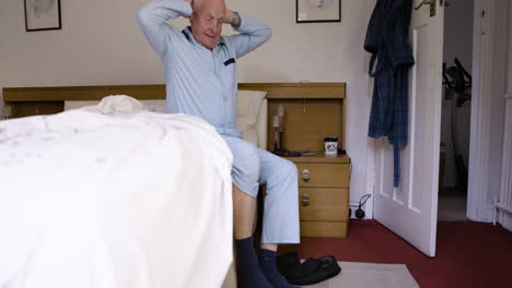 Elderly man getting out of bed