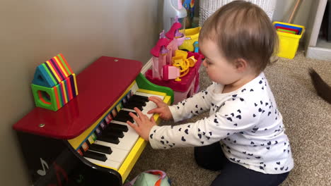 Ein-Videoclip-Im-Heimkino-Stil-Eines-Kleinen-Mädchens,-Das-Zu-Hause-Ein-Spielzeugklavier-Spielt