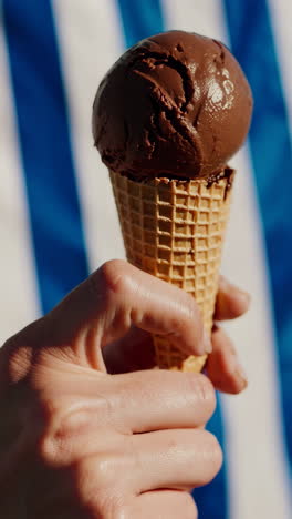 hand holding a chocolate ice cream cone