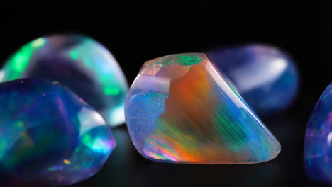 close-up of vibrant iridescent opals on a dark background