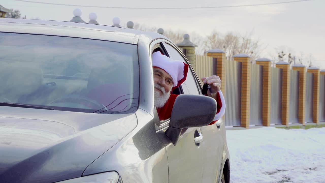 santa claus se sienta dentro de su nuevo coche y agita las llaves