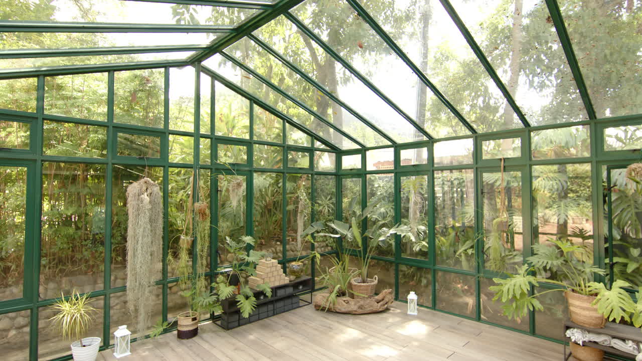 Empty glass house with potted plants and yoga mat on wooden floor, copy space