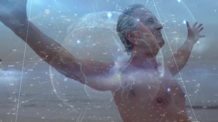 Eldre mann som ser mot horisonten, hever armene ved strandlinjen, genererer en digital globus som synkroniseres for teknologi.