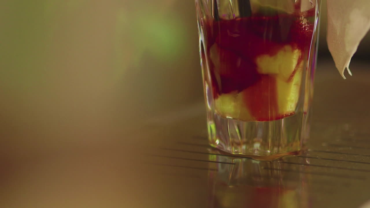 el camarero prepara una bebida de cerca de la fruta exprimida