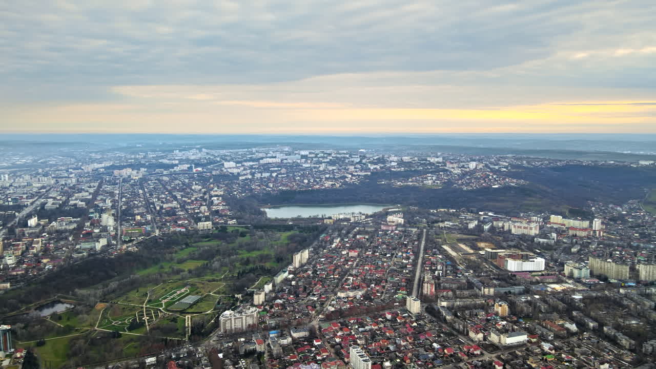 Aerial drone view of Chisinau. Panorama view of multiple buildings, roads and bare trees, park and a lake. Good weather. Moldova