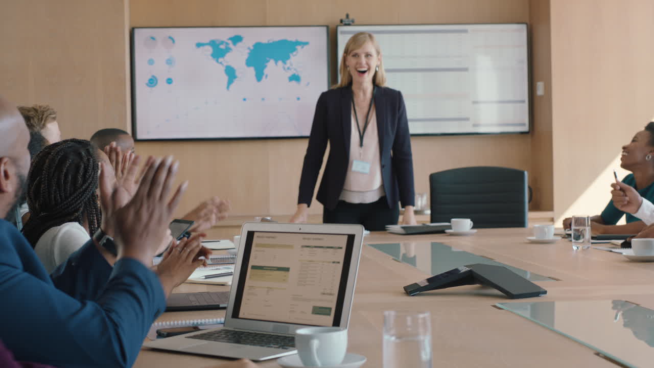 donna d'affari che presenta una soluzione di successo agli azionisti che festeggia con applausi che congratula la dirigente per la crescita delle vendite che batte le mani nella sala riunioni dell'ufficio