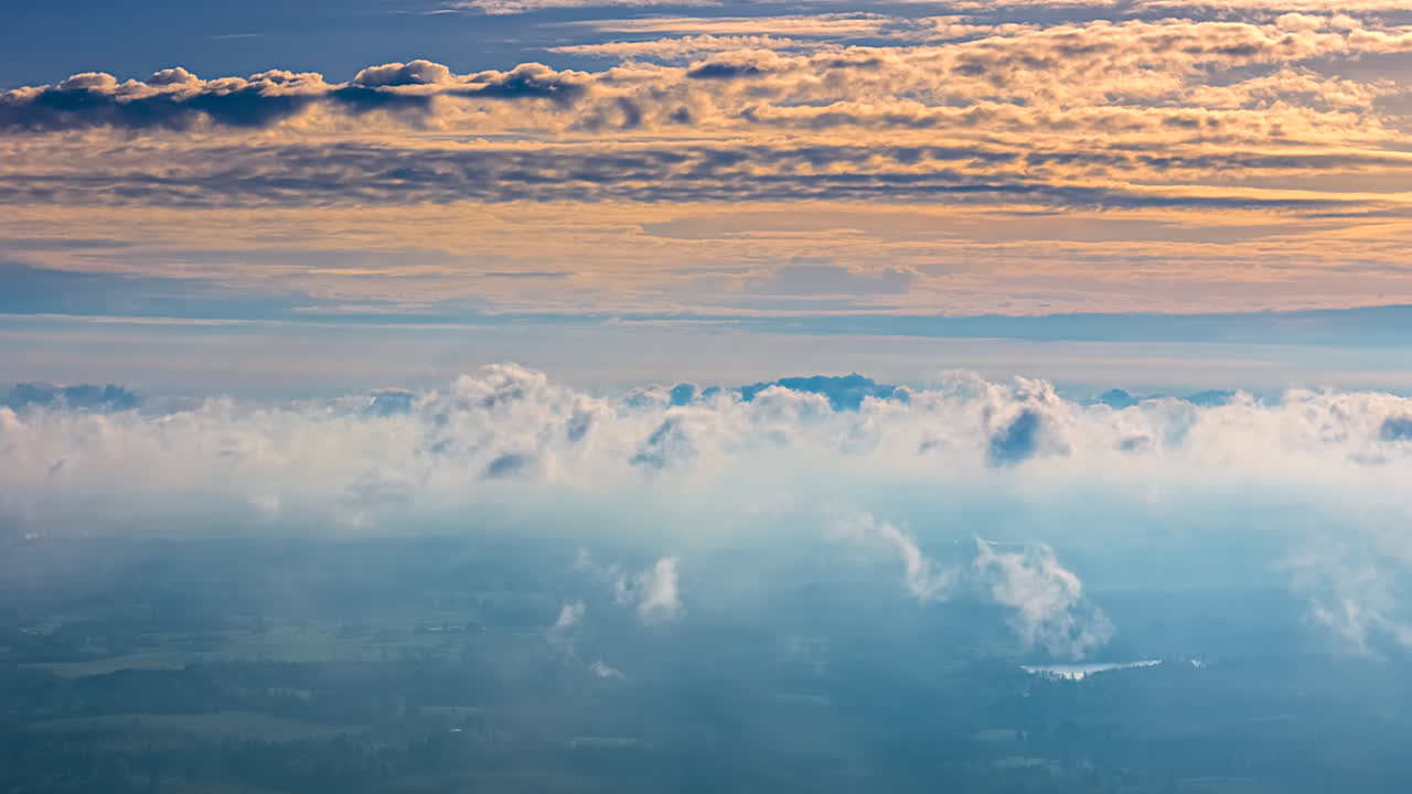 High above the Earth looking through layers of clouds at sunset - colorful aerial time lapse cloudscape
