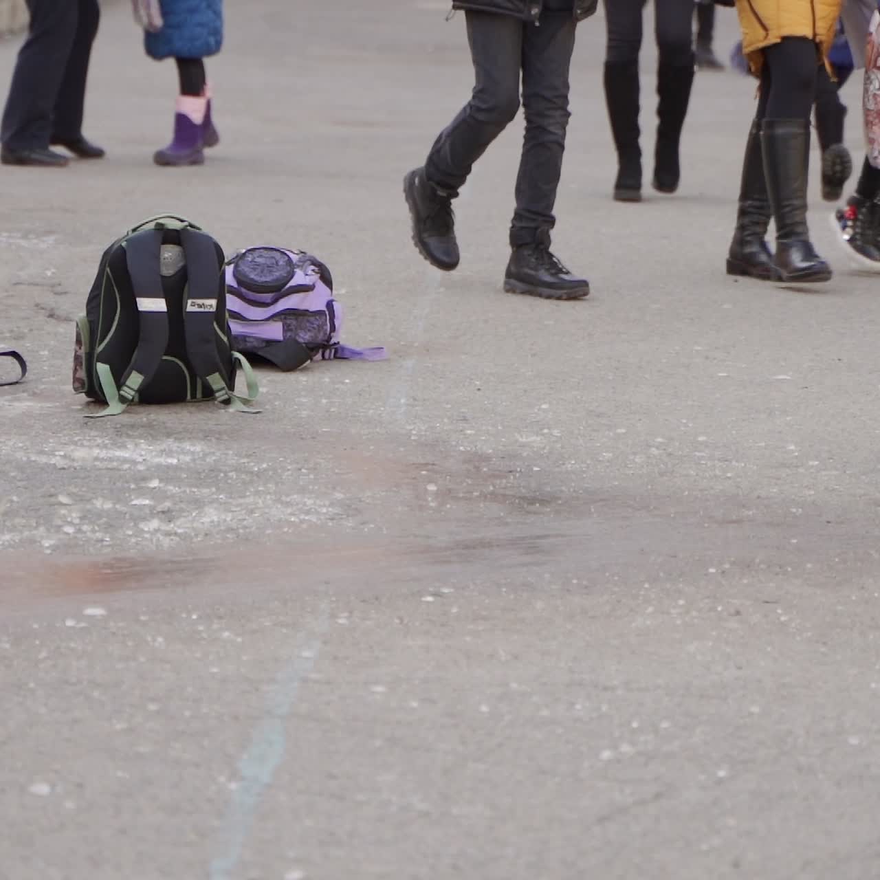Close-up. Happy kids slide on the ice. Frosty winter day. Winter fun in the schoolyard