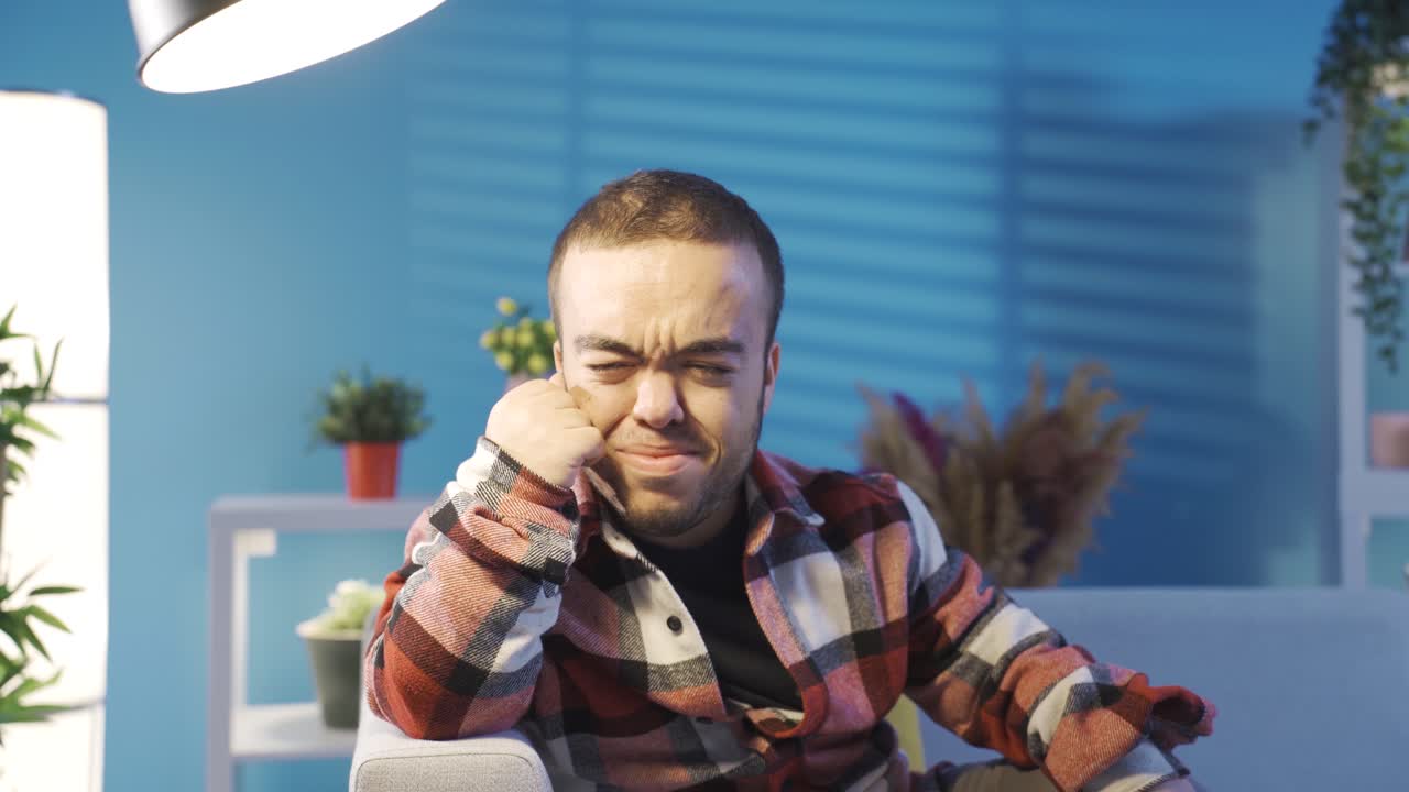 un joven deprimido con enanismo llorando solo en casa. un joven discapacitado sufre.