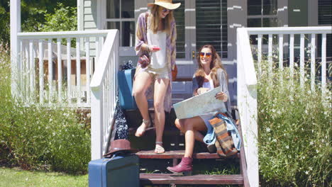 beautiful friends planning their road trip with suitcase and map and taking selfie