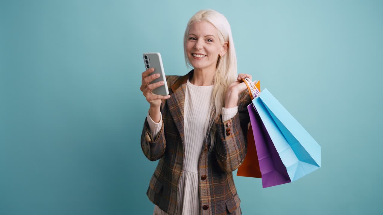 Donna felice con borse della spesa che naviga sullo smartphone