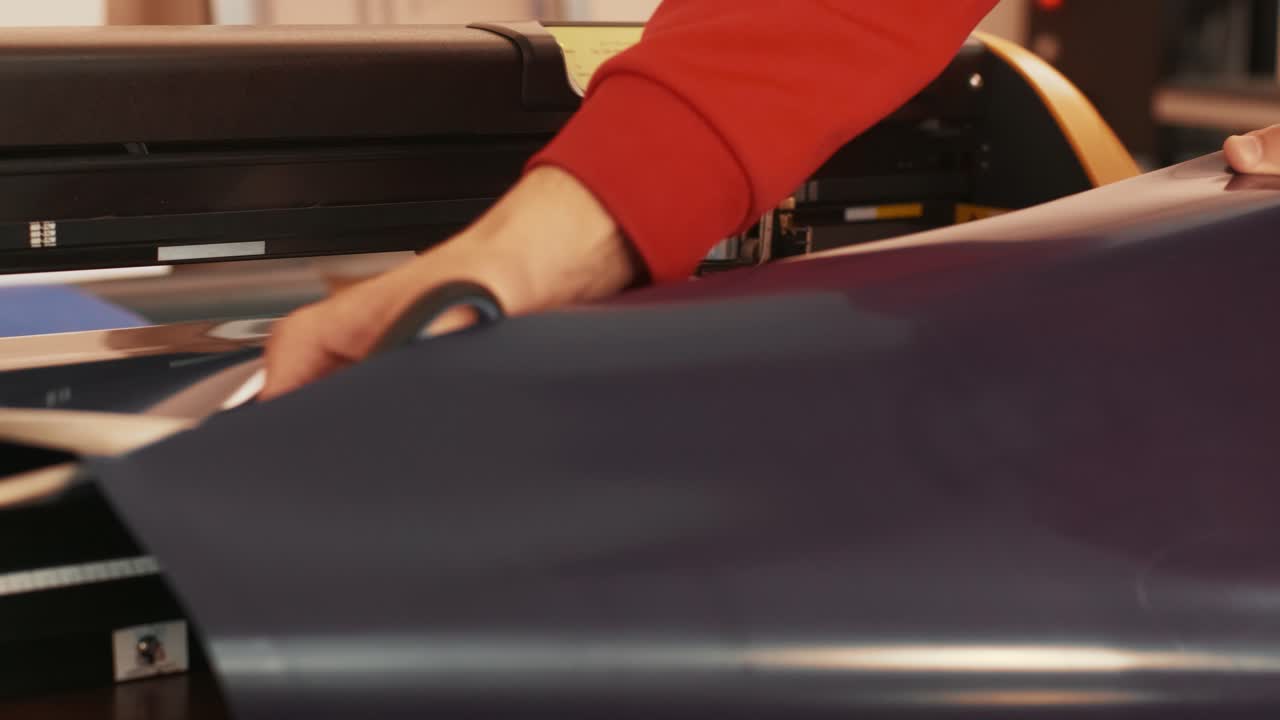 Skillful seamstress's fingers carefully holding membrane and cutting out pattern, close-up of scissors.