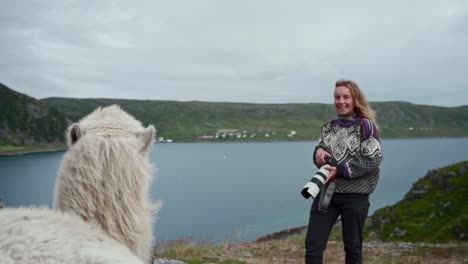 woman with camera laughs at the white camel in norway