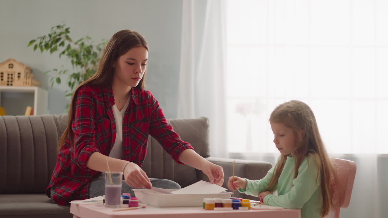 el maestro pone papel en la bandeja haciendo arte ebru con el estudiante