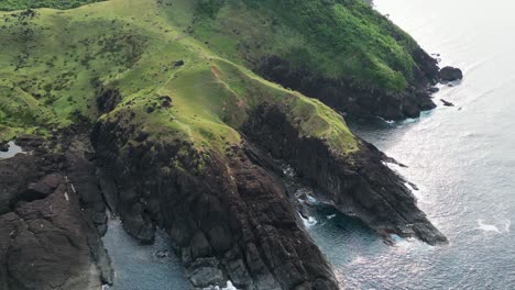 the lush green coastline of baras in catanduanes, with cliffs descending into the sea, aerial view