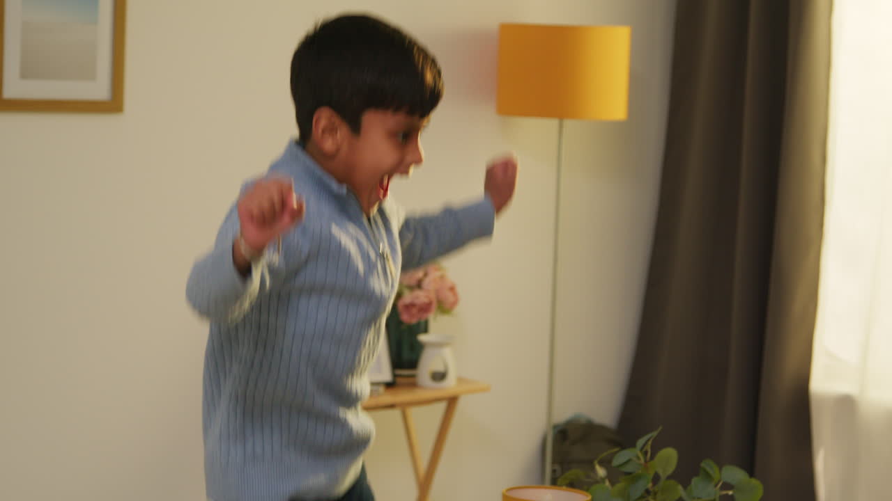 혼란스러운 어린 소년은 집에서 소파 라운지 1에 뛰어다니며 나게 행동합니다.