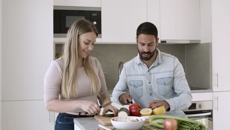 happy attractive young couple cooking salad together