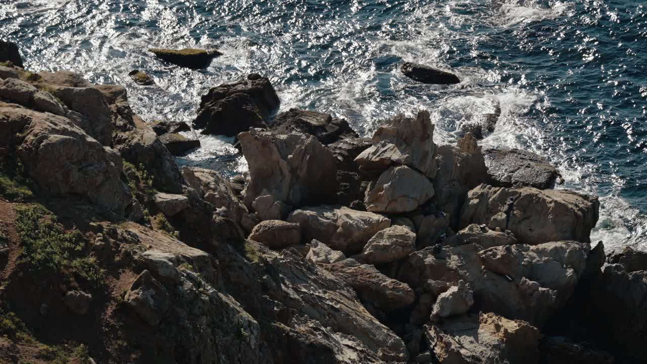 Waves crash against rugged rocks along the Atlantic coastline in Tangier, Morocco