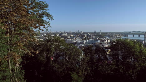 camera rises from behind fence to reveal podil district of kiev on a beautiful autumn morning