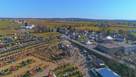 an aerial view of an amish mud sale with buggies, farm equipment and other crafts in early spring