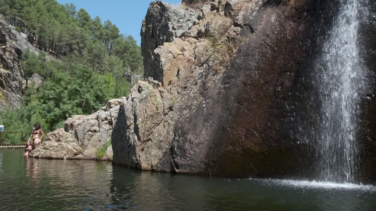 People in natural pool at Pego waterfall, Penha Garcia. Portugal