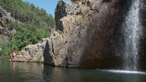 people in natural pool at pego waterfall, penha garcia. portugal