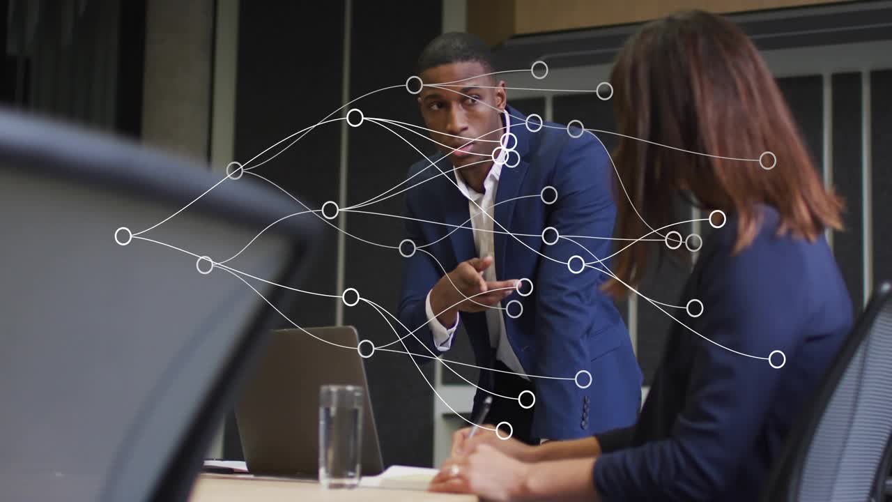 Man approaching peer and leaning while illustrating business plan with transparent network overlay